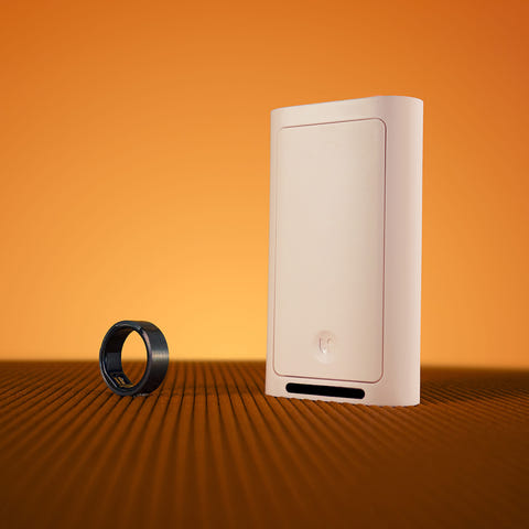 Gray Lotus Ring and a white Switch Cover on a brown textured surface.