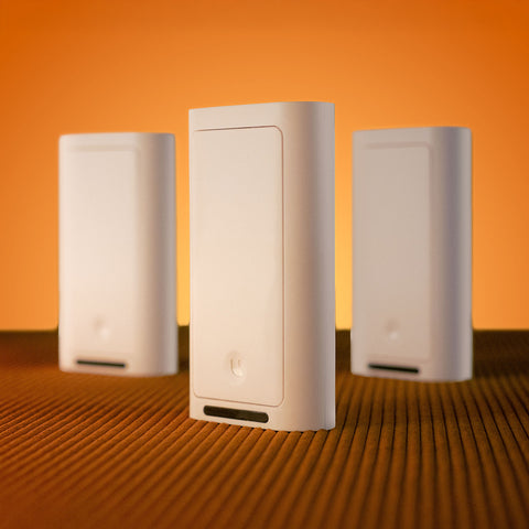 Three white Lotus Switch covers standing upright on a brown textured surface
