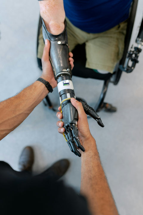 hand grasping a prosthetic hand, resembling a handshake