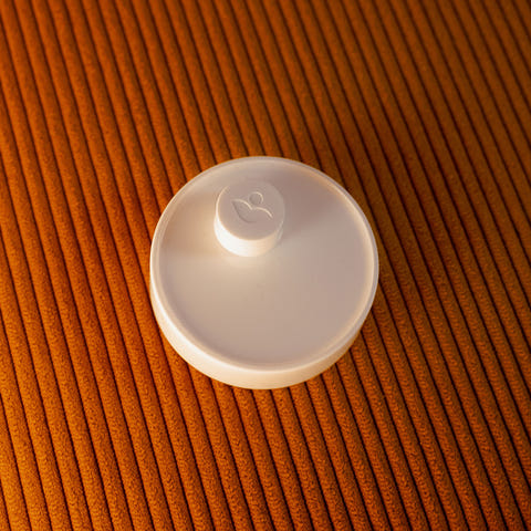 White Lotus Ring Charging platform on a brown textured surface